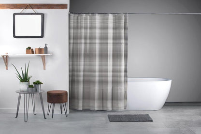 Bei diesem Bild handelt es sich um ein Milieu-Foto in einem Badezimmer. Hierbei sieht man einen aufgehängten Duschvorhang mit grauem Karo-Muster, dahinter eine Badewanne. Vor dem Vorhang auf dem Boden befindet sich eine Duschmatte in der Farbe grau.