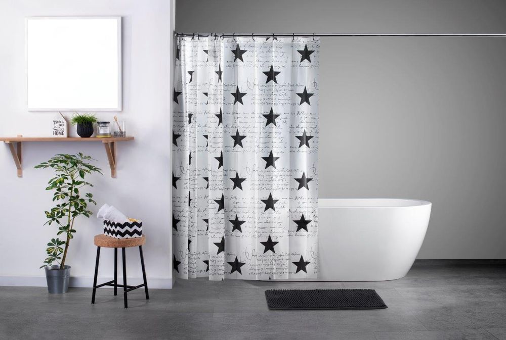 Bei diesem Bild handelt es sich um ein Foto in einem Badezimmer. Hierbei sieht man einen aufgehängten weißen Duschvorhang bedruckt mit schwarzen Sternen, dahinter eine Badewanne. Vor dem Vorhang am Boden befindet sich eine Duschmatte in der Farbe schwarz.