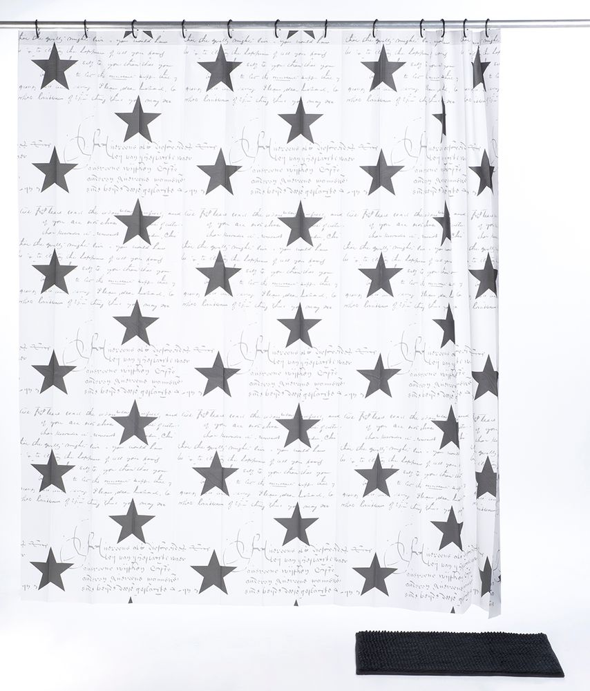 Auf dem Bild einen aufgehängten, weißen Duschvorhang, bedruckt mit einem schwarzem Sterne-Muster, vor dem Vorhang am Boden befindet sich eine Duschmatte in der Farbe schwarz.